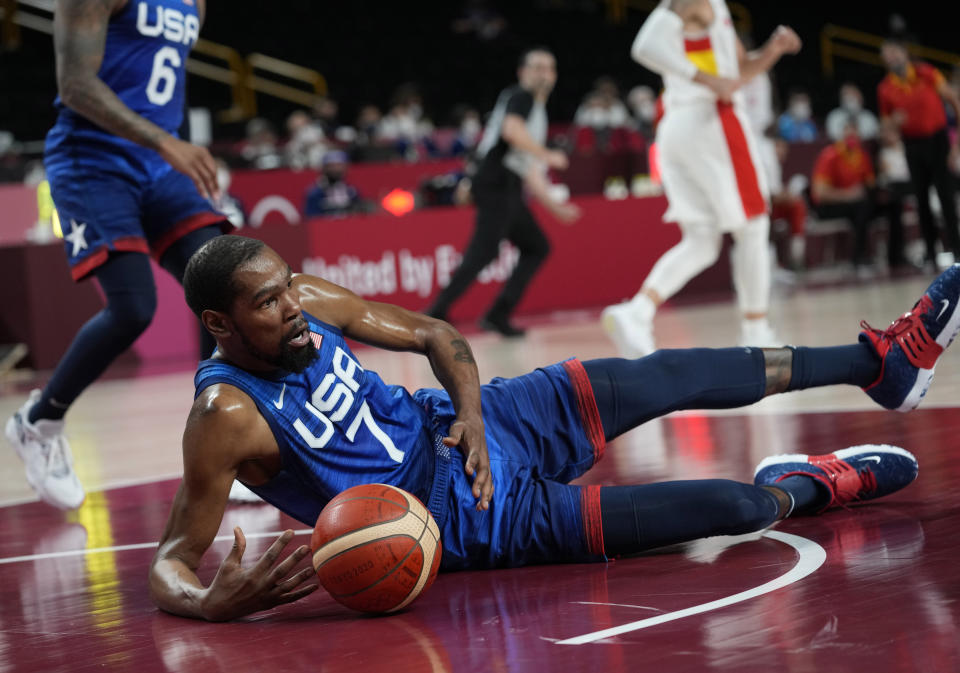 United States' Kevin Durant (7) falls on the court in an attempt to take control of the ball during men's basketball quarterfinal game against Spain at the 2020 Summer Olympics, Tuesday, Aug. 3, 2021, in Saitama, Japan. (AP Photo/Eric Gay)