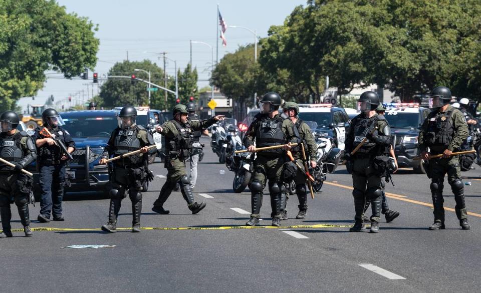 Modesto Police officers and Sheriffs deputies decend on Planned Parenthood office after an altercation between individuals during a protest on McHenry Ave to oppose the Straight Pride event in Modesto, Calif., on Saturday, August 27, 2022.