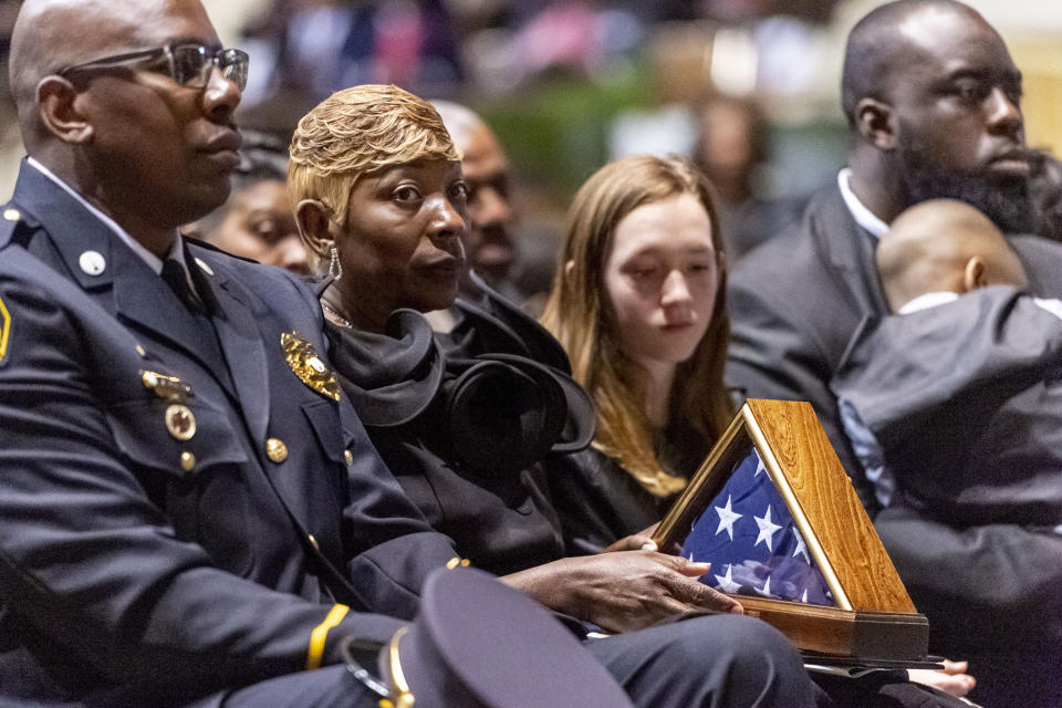 Joann Williams holds the U.S. flag that flew over the Capitol to honor her husband, during the memorial service for slain Lowndes County Sheriff "Big John" Williams, Monday, Dec. 2, 2019, in Montgomery, Ala. (AP Photo/Vasha Hunt)