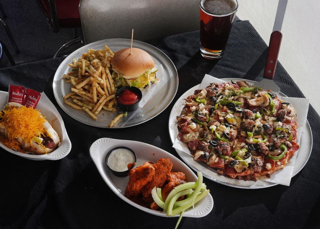 Smash burger with fries, wings (spicy garlic), C-Bus coney dog, classic supreme pizza and a Great Lakes beer photographed at Ash & Em, 541 S. High St.