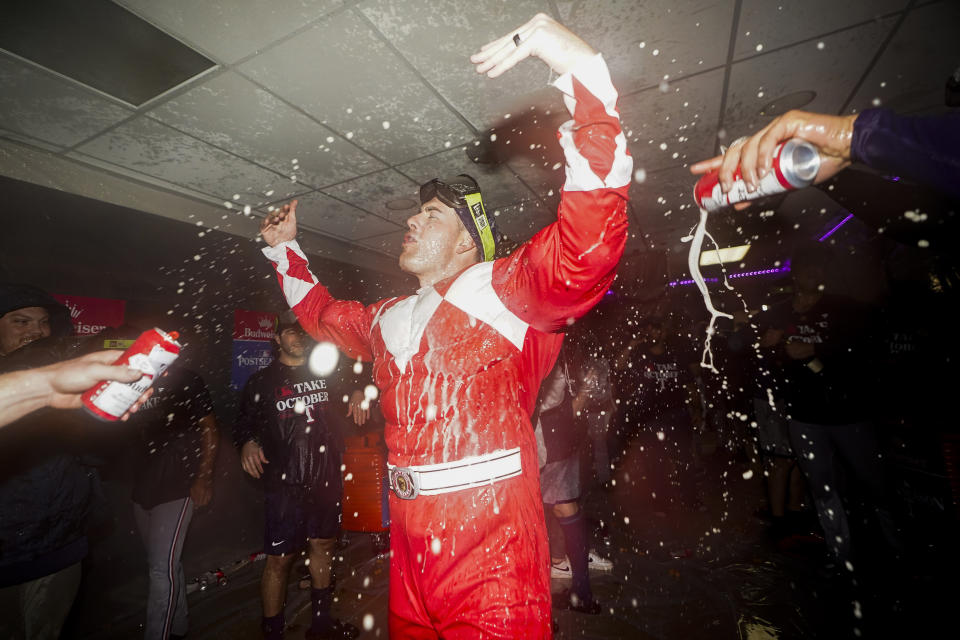 Texas Rangers assistant hitting coach Seth Conner wears a Power Rangers costume as the team celebrates clinching a playoff berth after a 6-1 win over the Seattle Mariners in a baseball game Saturday, Sept. 30, 2023, in Seattle. (AP Photo/Lindsey Wasson)