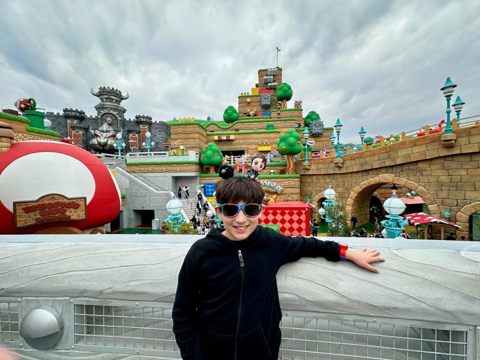 boy posing in front of super nintendo world in universal japan