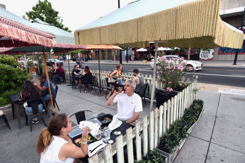 FILE PHOTO: Cori Thune (L) and Phillip Thune dine outdoors at Park on Fremont as restaurants are opening for business on sidewalks as restrictions to prevent the spread of coronavirus disease (COVID-19) are eased in Las Vegas
