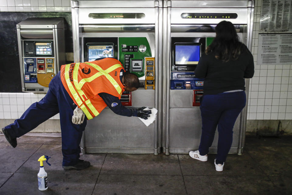 FILE - In this March 20, 2020, file photo an MTA employee sanitizes surfaces at the Classon Ave. and Lafayette Ave. subway station with bleach solutions due to COVID-19 concerns in the Brooklyn Borough of New York. (AP Photo/John Minchillo, File)