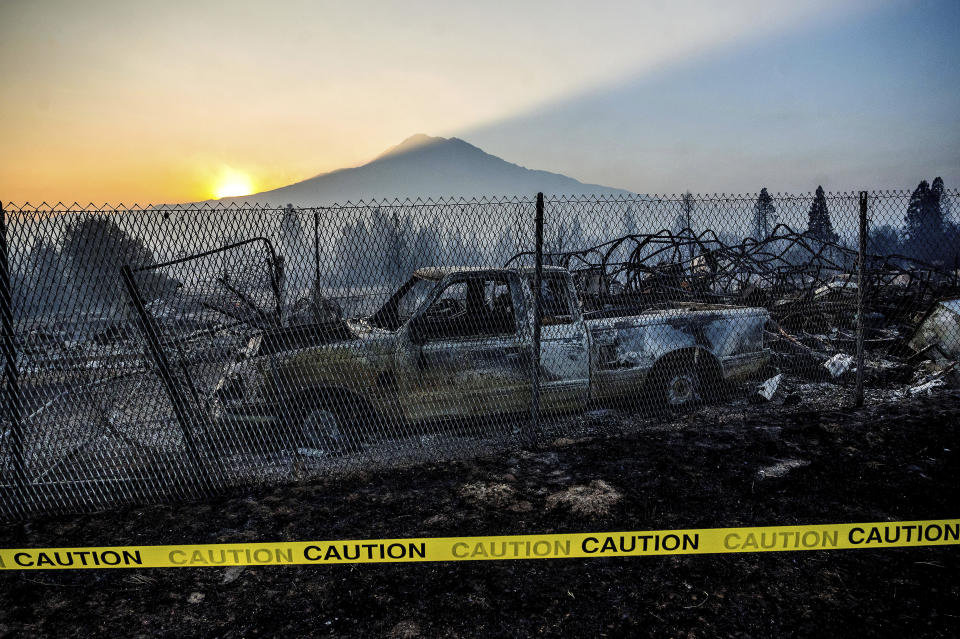 The sun rises over Mt. Shasta and homes destroyed by the Mill Fire on Saturday, Sept. 3, 2022, in Weed, Calif. (AP Photo/Noah Berger)