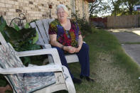 Pamela Polk sits next to the home she rents in Arlington, Texas, on Monday, Oct. 25, 2021. A TEP Barnett fracking site, hidden by the fence and trees behind her, sits just a few hundred feet from the house and those of her neighbors, most of them also renters. TEP Barnett is a subsidiary of French energy giant Total Energies. Polk has chronic obstructive pulmonary disease and, since moving in a decade ago, said her grandson has developed asthma. She worries that the well site has had an impact on their health. "I'm frustrated," she said. (AP Photo/Martha Irvine)