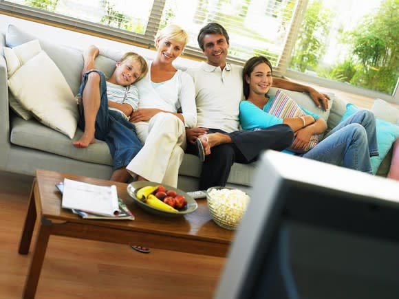 A family watching TV on the couch