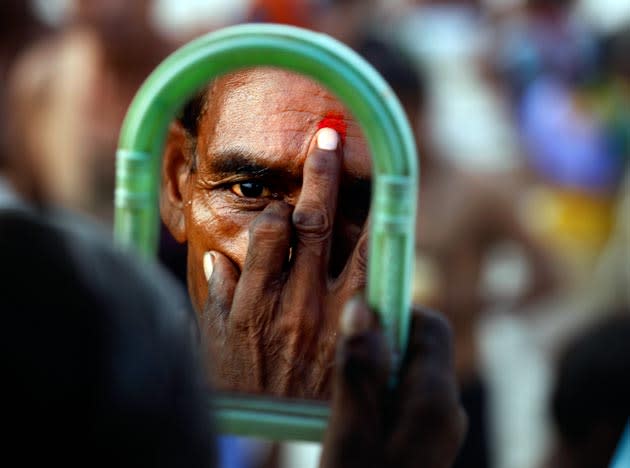 Hindu holy man, applies Tilak, or Vermillion paste after taking a holy dip on the banks of the River Ganges on the occasion of Guru Purnima or full moon day dedicated to the Guru or masters in ones life, in Allahabad, India, Friday, July 15, 2011. (AP Photo/Rajesh Kumar Singh)