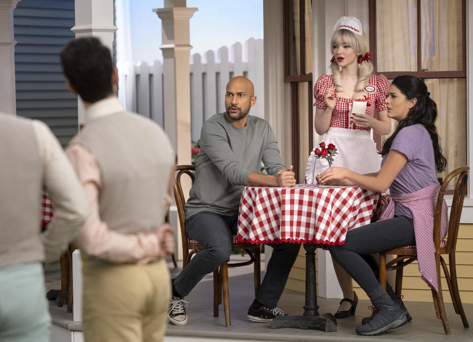 This image released by Apple TV+ shows Keegan-Michael Key, background from left, Dove Cameron and Cecily Strong in a scene from "Schmigadoon!,” premiering Friday. (Apple TV+ via AP)