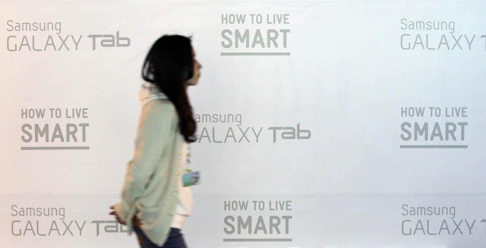 A woman walks by a billboard of Samsung Electronics Co. at a showroom of its headquarters in Seoul, South Korea, Friday, April 6, 2012. Samsung Electronics is expecting a record operating profit of $5.1 billion for the first quarter of this year. The Suwon, South Korea-based company said Friday the result would be a 97 percent rise from its operating profit a year earlier. (AP Photo/Lee Jin-man)