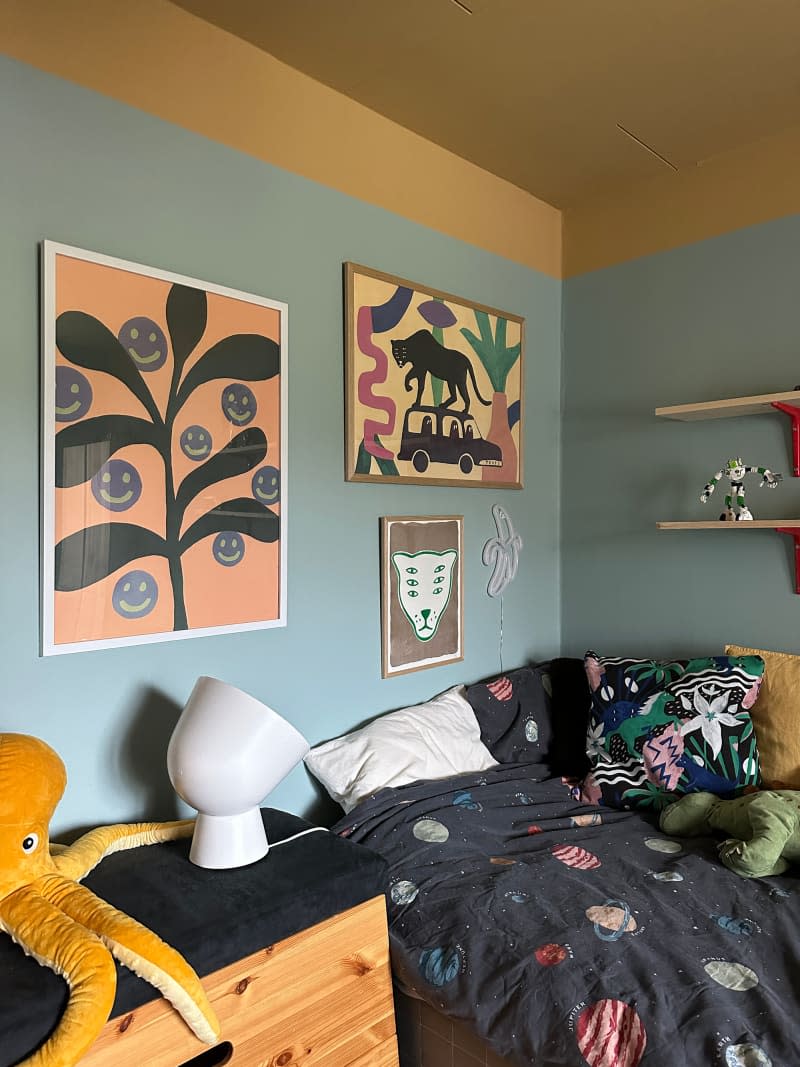 Colorful art prints decorate the bedroom walls.