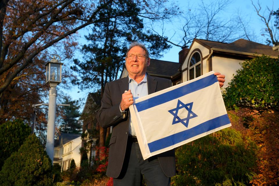 Marty Polack poses with an Israeli flag outside his Teaneck home, Thursday, November 16, 2023.