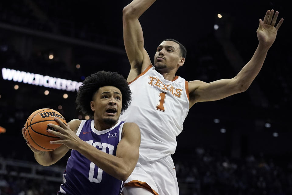 TCU guard Micah Peavy (0) looks to shoot under pressure from Texas forward Dylan Disu (1) during the first half of an NCAA college basketball game in the semifinal round of the Big 12 Conference tournament Friday, March 10, 2023, in Kansas City, Mo. (AP Photo/Charlie Riedel)