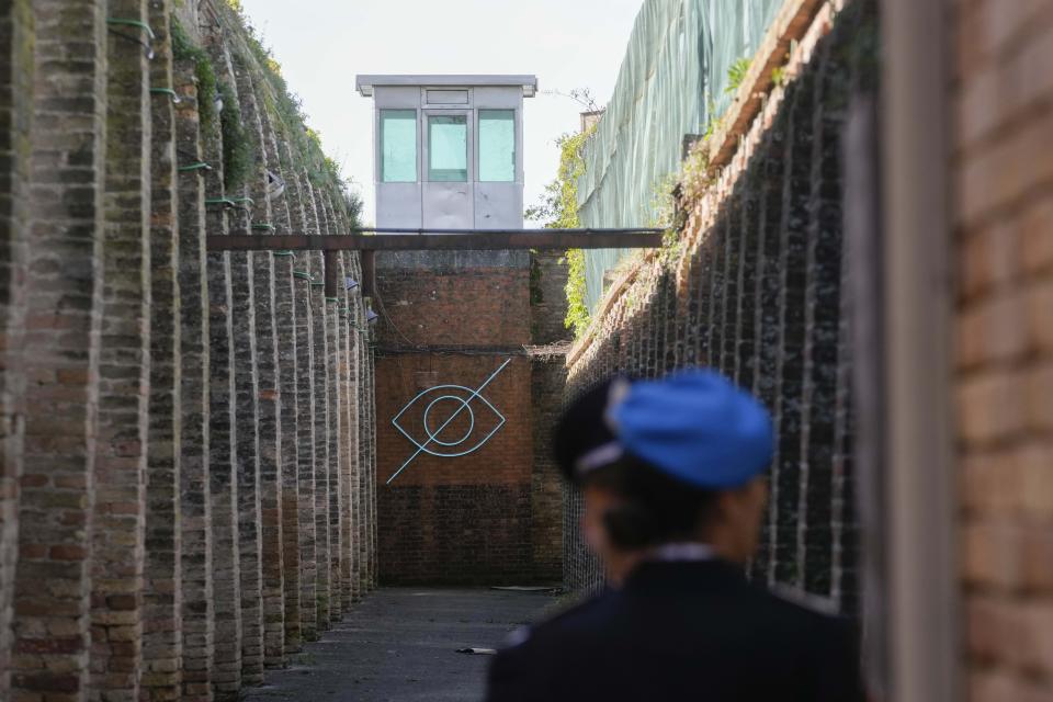 The installation 'White Sight' by artist Claire Fontaine is displayed inside the women's prison at the Giudecca island during the 60th Biennale of Arts exhibition in Venice, Italy, Wednesday, April 17, 2024. A pair of nude feet dirty, wounded and vulnerable are painted on the façade of the Venice women's prison chapel, the work of Italian artist Maurizio Cattelan and part of the Vatican's pavilion at the Venice Biennale in an innovative collaboration between inmates and artists. (AP Photo/Luca Bruno)