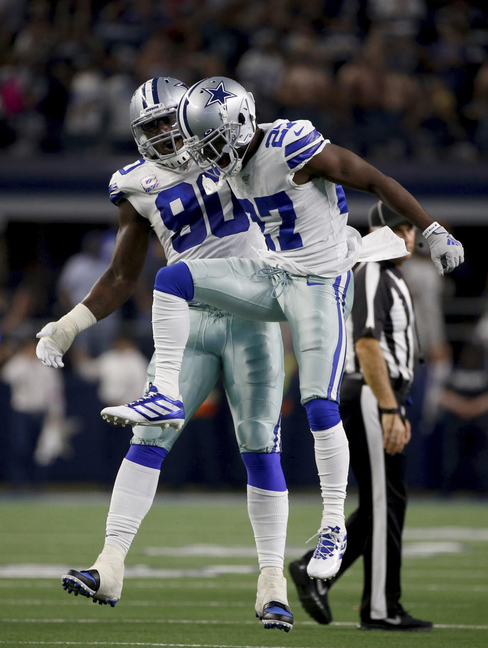Dallas Cowboys defensive end Demarcus Lawrence (90) and cornerback Jourdan Lewis (27) celebrate a sack of Philadelphia Eagles' Carson Wentz by Lewis in the first half of an NFL football game in Arlington, Texas, Sunday, Oct. 20, 2019. (AP Photo/Ron Jenkins)