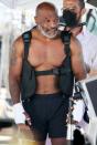 <p>Mike Tyson shows off his muscles on Wednesday during a photo shoot on the beach in Los Angeles. </p>