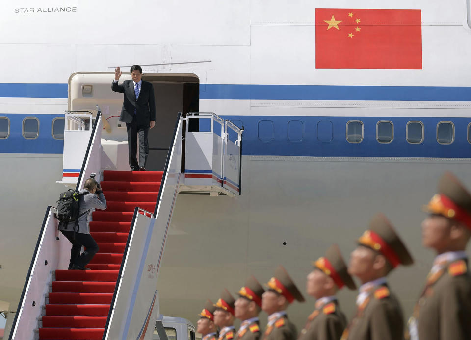 Senior Chinese official Li Zhanshu, top, waves upon arrival at Pyongyang International Airport in Pyongyang, North Korea, Saturday, Sept. 8, 2018. Li, the Chinese ruling party's third highest official, will attend a big military parade on the 70th anniversary of North Korea's founding on Sunday, Sept. 9. (Kyodo News via AP)