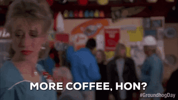 Woman in bustling diner asks, "More coffee, hon?" with people in background. Hashtag #GroundhogDay