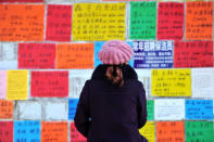 A woman looks at job advertisements on a wall in Qingdao West Coast New Zone in Shandong province, China January 17, 2019. REUTERS/Stringer