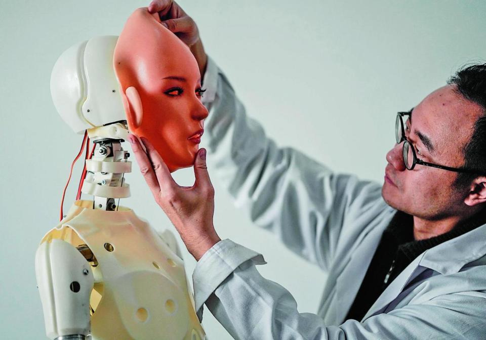 Face time: An engineer adjusts a sex robot (AFP/Getty Images)