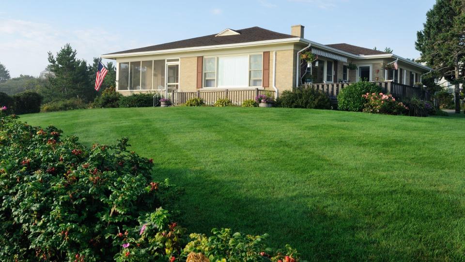 Classic american bungalow from the 60's or 70's with freshly cut lawn.