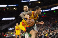 Atlanta Hawks forward John Collins (20) drives past Boston Celtics forward Jayson Tatum during the second half of an NBA basketball game Friday, Jan. 28, 2022, in Atlanta. (AP Photo/Hakim Wright Sr.)