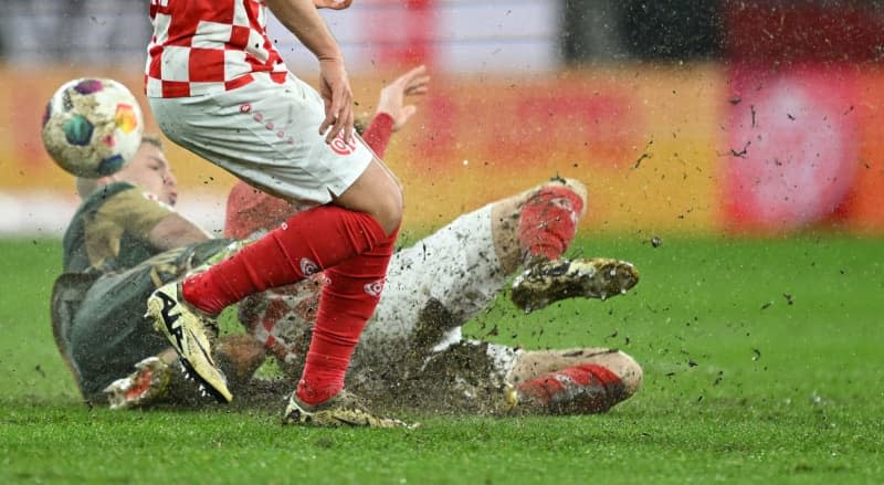 Mainz's Nadiem Amiri (Front) and Sepp van den Berg (R) battle for the ball with Union's Andras Schaefer during the German Bundesliga soccer match between 1. FSV Mainz 05 and 1. FC Union Berlin at the Mewa Arena. Arne Dedert/dpa