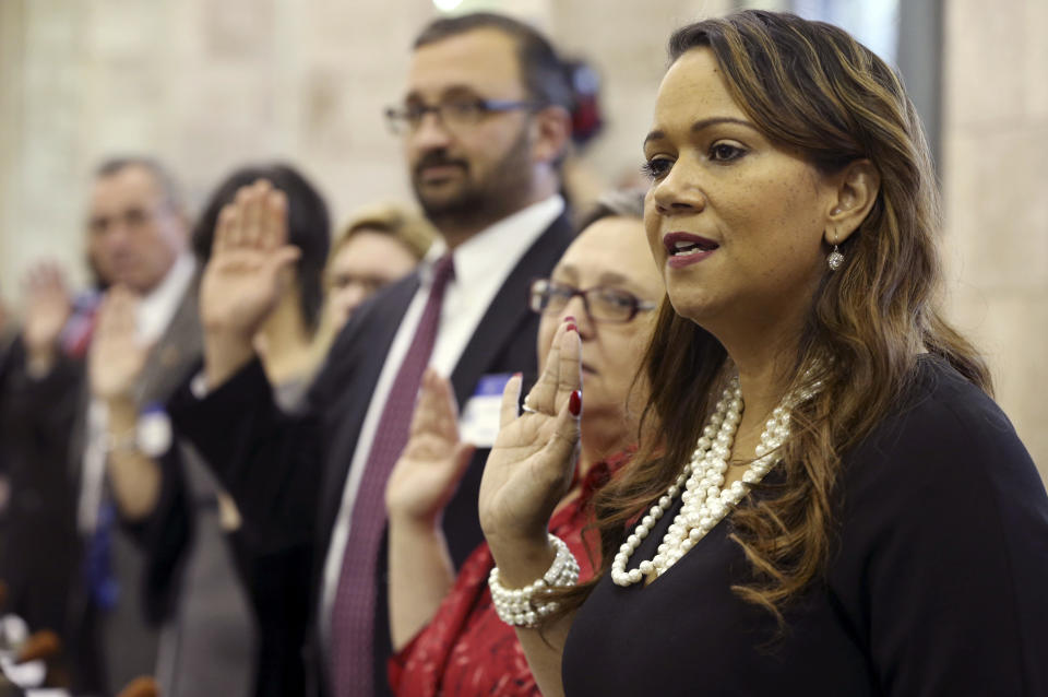 Lizette Delgado-Polanco, right, a presidential elector, stands with others of New Jersey's Electoral College delegation as they are sworn in before they formally selected Democrat Hillary Clinton for president at the Statehouse, Monday, Dec. 19, 2016, in Trenton, N.J. (AP Photo/Mel Evans)