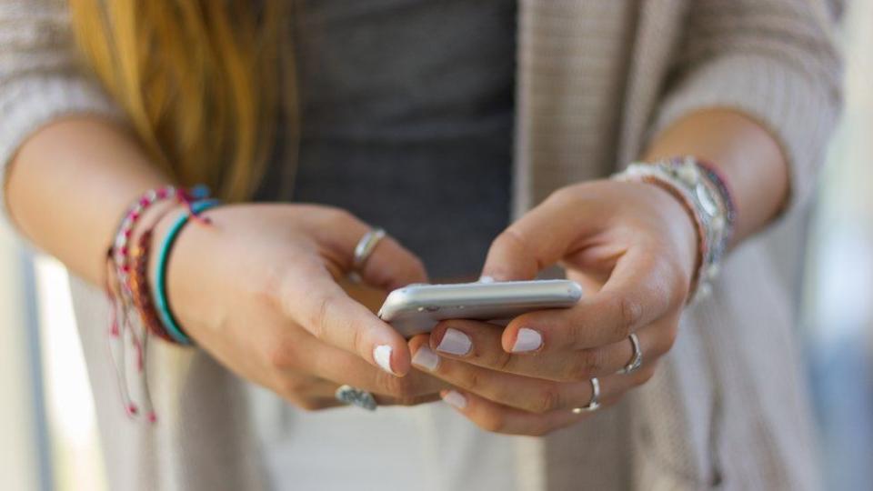 Mujer con un celular en la mano