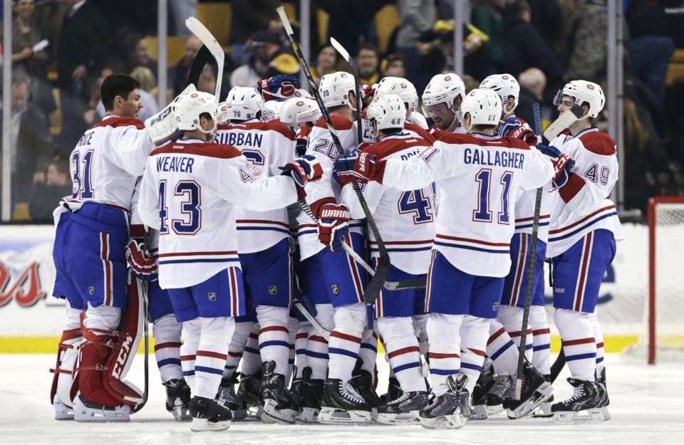 Montreal Canadiens center Alex Galchenyuk is surrounded by teammates after his winning goal against Boston Bruins goalie Tuukka Rask in a shootout on of an NHL hockey game, Monday, March 24, 2014, in Boston. The Canadiens defeated the Bruins 2-1. (AP Photo/Charles Krupa)