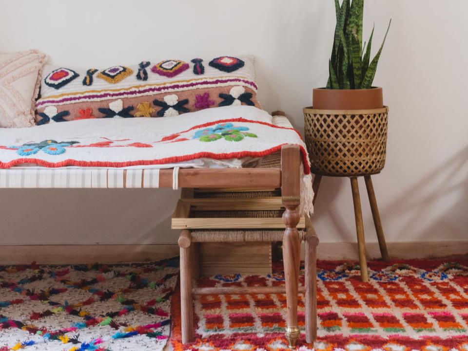 colorful room with wall art, couch and layered rugs