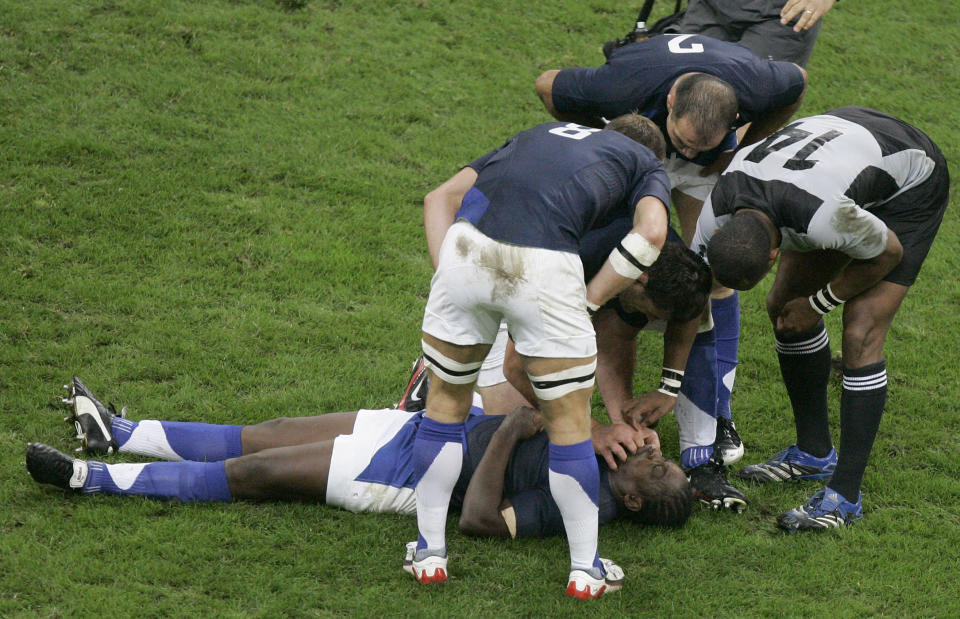 FILE - Serge Betsen of France lays on the pitch after taking a knock during the Rugby World Cup quarterfinal match between France and New Zealand at the Millennium Stadium in Cardiff, Wales, on Oct. 6, 2007. The Rugby World Cup will take place to the backdrop of a concussion lawsuit that has similarities to one settled by the NFL in 2013 at a likely cost of more than $1 billion. (AP Photo/Christophe Ena, File)