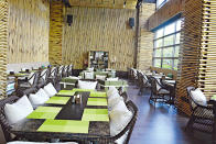 「欣迎 Cafe」的牆壁鋪了竹子，餐桌上的餐墊是青綠色，色調似竹海樹林。（周翠玲攝）