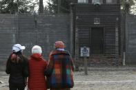 People walk in the Auschwitz museum a day prior to the 75th anniversary of the liberation of Nazi German concentration and extermination camp, Auschwitz