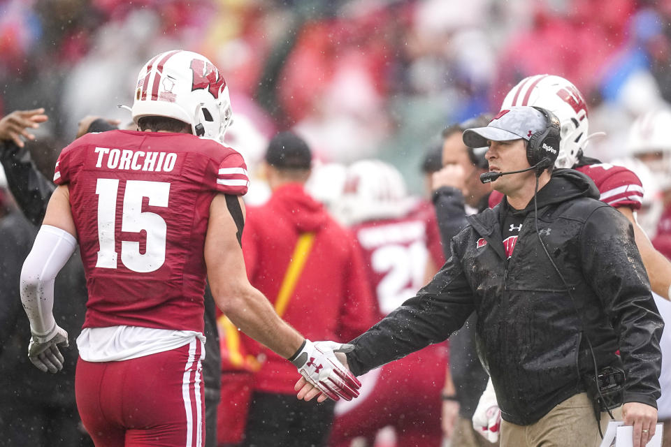 Wisconsin interim head coach Jim Leonhard greats safety John Torchio (15) after a play in the first half of an NCAA college football game against Maryland, Saturday, Nov. 5, 2022, in Madison, Wis. (AP Photo/Andy Manis)