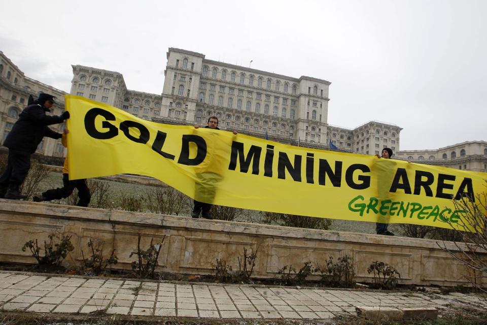 Greenpeace activists hold a banner in the yard of Romania's Parliament in Bucharest