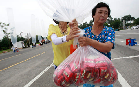 North Korean defectors release a balloon carrying chocolate pies and cookies - Credit: Ahn Young-joon/AP 