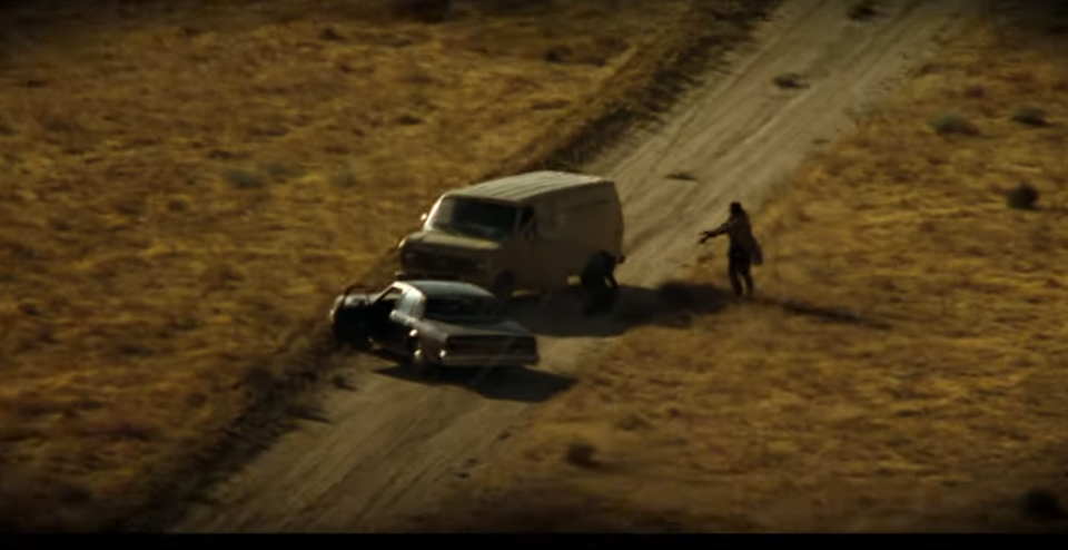A helicopter point of view of a van approaching brad pitt and morgan freeman in Seven