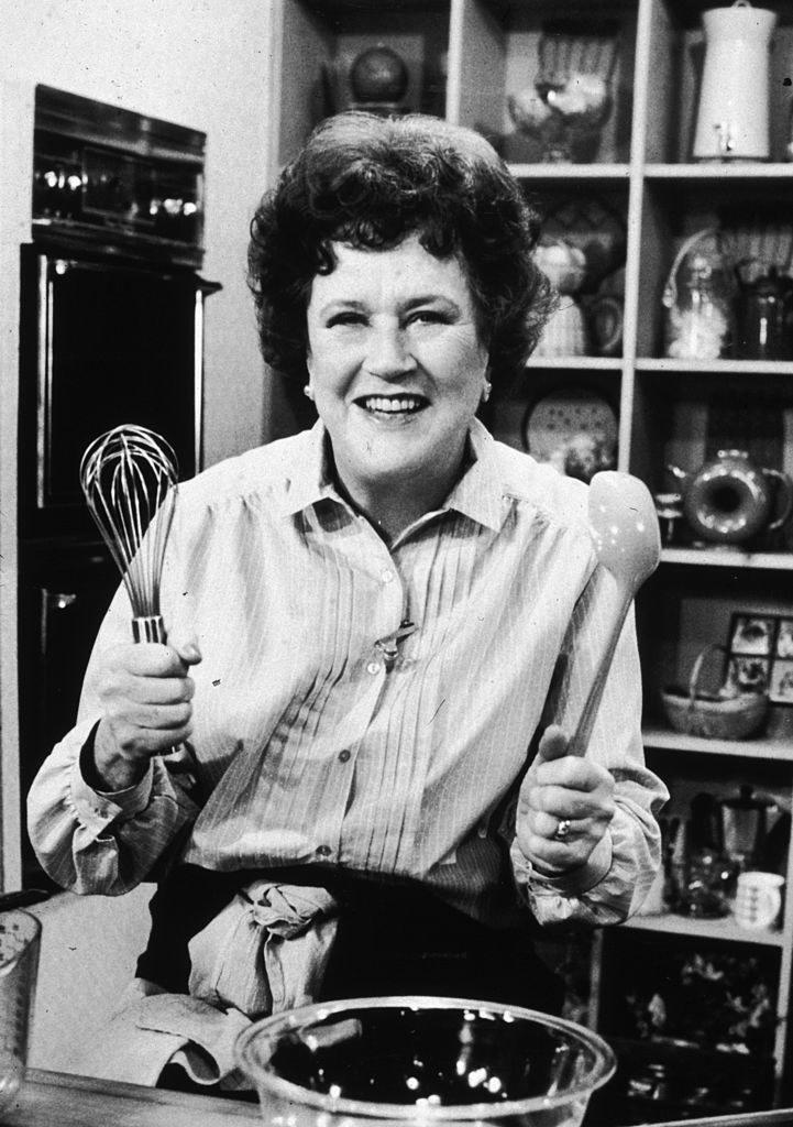 Julia Child posing with a whisk and spoon