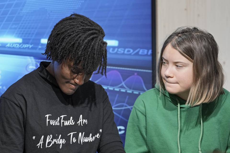 Climate activists Greta Thunberg of Sweden, right, watches Vanessa Nakate of Uganda, left, at a press conference at the World Economic Forum in Davos, Switzerland Thursday, Jan. 19, 2023. The annual meeting of the World Economic Forum is taking place in Davos from Jan. 16 until Jan. 20, 2023. (AP Photo/Markus Schreiber)