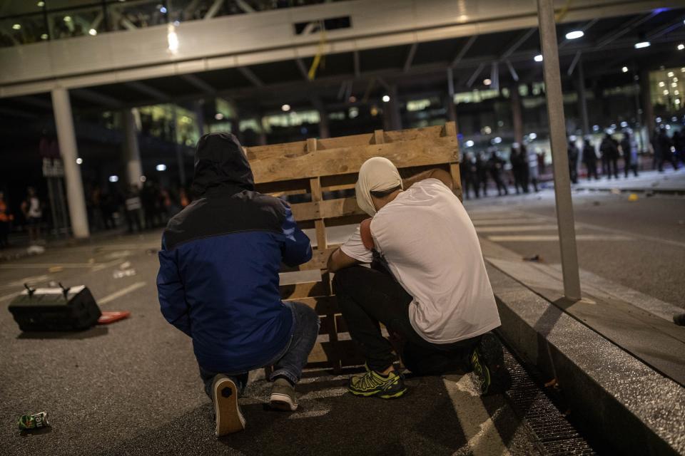 Protesters use makeshift barricades during a demonstration at El Prat airport, outskirts of Barcelona, Spain, Monday, Oct. 14, 2019. Spain's Supreme Court on Monday sentenced 12 prominent former Catalan politicians and activists to lengthly prison terms for their roles in a 2017 bid to gain Catalonia's independence, sparking protests across the wealthy Spanish region. (AP Photo/Bernat Armangue)