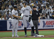 New York Yankees third base coach Luis Rojas, left, congratulates Aaron Judge after he reached third base on Giancarlo Stanton's single against the Tampa Bay Rays during the fourth inning of a baseball game Friday, May 10, 2024, in St. Petersburg, Fla. (AP Photo/Steve Nesius)