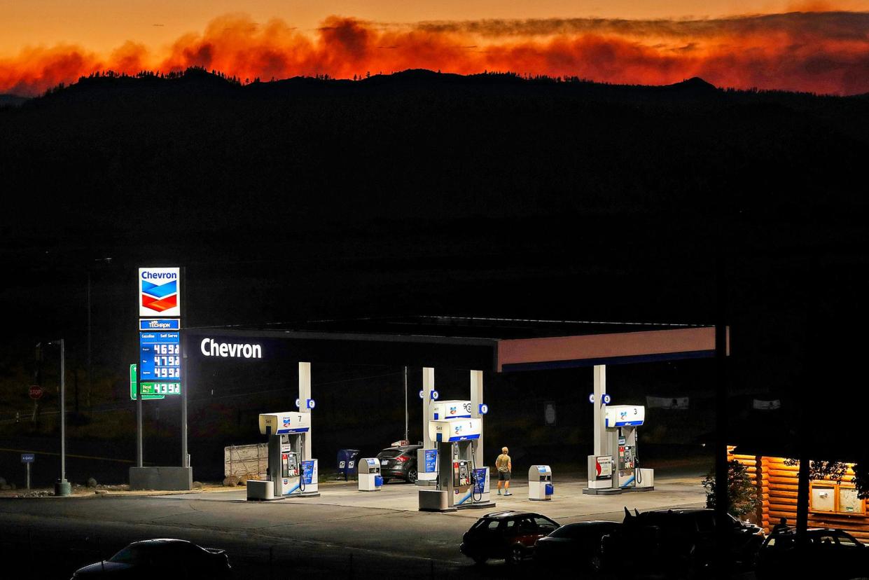 <span>The Beckwourth Complex fires burn beyond a gas station in Lassen county, California, on 12 July 2021.</span><span>Photograph: Scott Strazzante/San Francisco Chronicle via Getty Images</span>