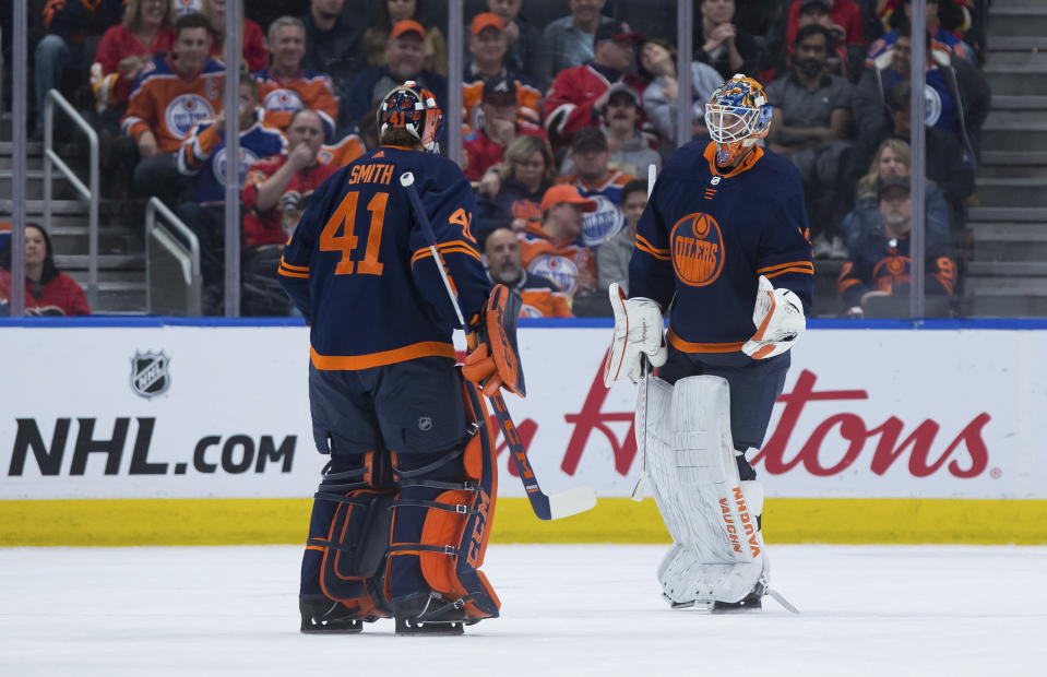Edmonton Oilers goalie Mikko Koskinen, right, of Finland, skates off the ice after being replaced by Mike Smith after allowing a fourth goal to the Calgary Flames, during the second period of an NHL hockey game Friday, Dec. 27, 2019, in Edmonton, Alberta. (Darryl Dyck/The Canadian Press via AP)