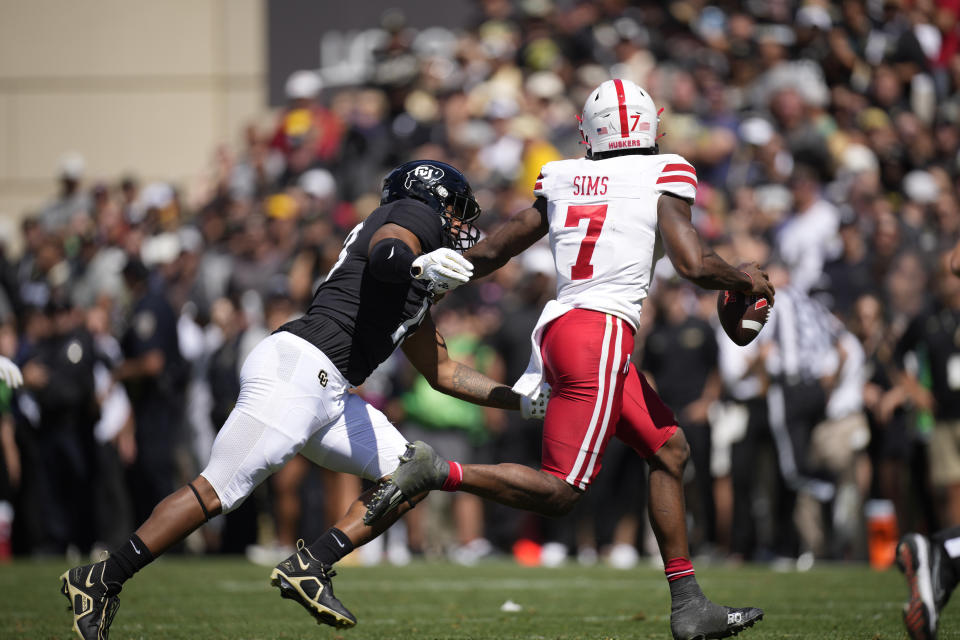 Colorado defensive end Sav'ell Smalls, left, forces Nebraska quarterback Jeff Sims to scramble out of the pocket in the second half of an NCAA college football game Saturday, Sept. 9, 2023, in Boulder, Colo. Sims was injured on the play and was helped off the field. AP Photo/David Zalubowski)