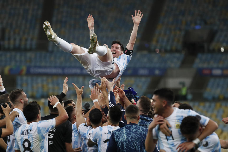 FILE - Teammates toss Argentina's Lionel Messi in the air after beating Brazil 1-0 in the Copa America final soccer match at the Maracana stadium in Rio de Janeiro, Brazil, July 10, 2021. Messi and Argentina will try to win their third straight major title when they defend their Copa America championship while Brazil hopes 17-year-old Endrick will combine with Vinícius Júnior and Rodrygo for success. (AP Photo/Bruna Prado, File)