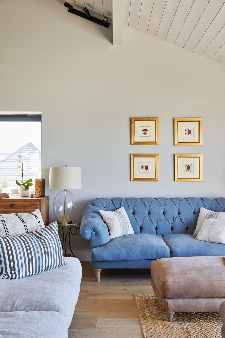 living room with two traditional style sofas in soft blue and grey and decorated with striped cushions