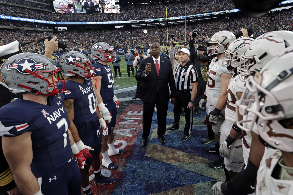 FILE - Defense Secretary Lloyd Austin flips the coin before the first half of an NCAA college football game between Army and Navy on Dec. 11, 2021, in East Rutherford, N.J. Army and Navy will line up their triple-option offenses on Saturday, Dec. 9, 2023, at the home of the New England Patriots for a day full of pageantry, tradition and a deeply rooted respect that comes with one of college football's fiercest rivalries. (AP Photo/Adam Hunger, File)