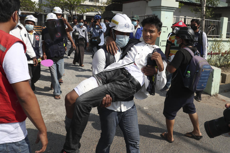 A protester wounded during a protest against a military coup is carried by his colleague in Mandalay, Myanmar, Sunday, Feb. 28, 2021. In the month since Feb. 1 coup, the mass protests occurring each day are a sharp reminder of the long and bloody struggle for democracy in a country where the military ruled directly for more than five decades. (AP Photo)