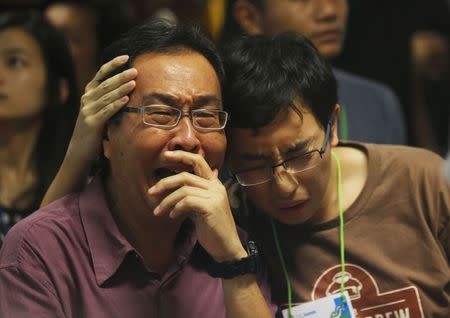 Family members of passengers onboard missing AirAsia flight QZ8501 cry at a waiting area in Juanda International Airport, Surabaya, December 30, 2014. REUTERS/Beawiharta